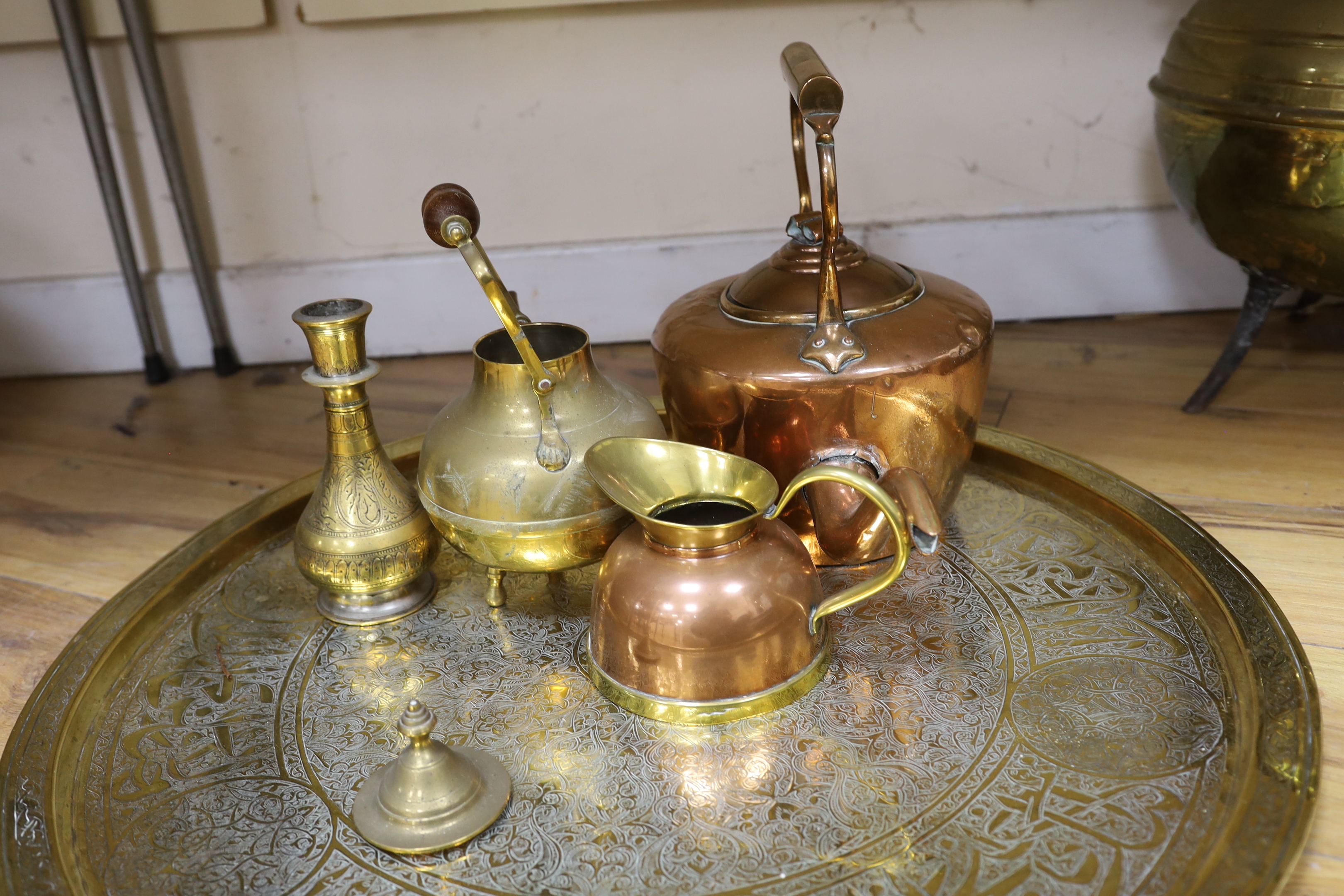 A brass cauldron shaped coal scuttle, a large circular tray, two kettles, a jug and a vase, tray 65cm diameter